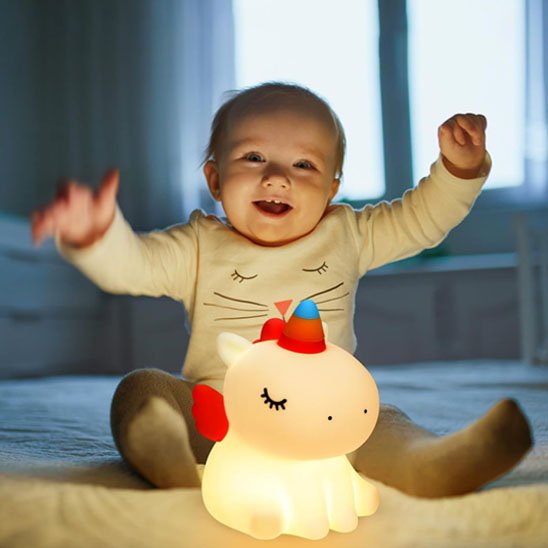 Veilleuse licorne bébé en silicone souple tenue par un enfant