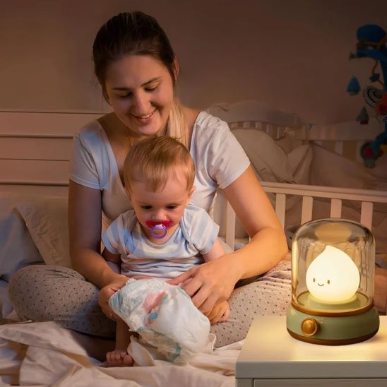 maman qui change bebe avec la lumiere tamisee de la veilleuse bebe