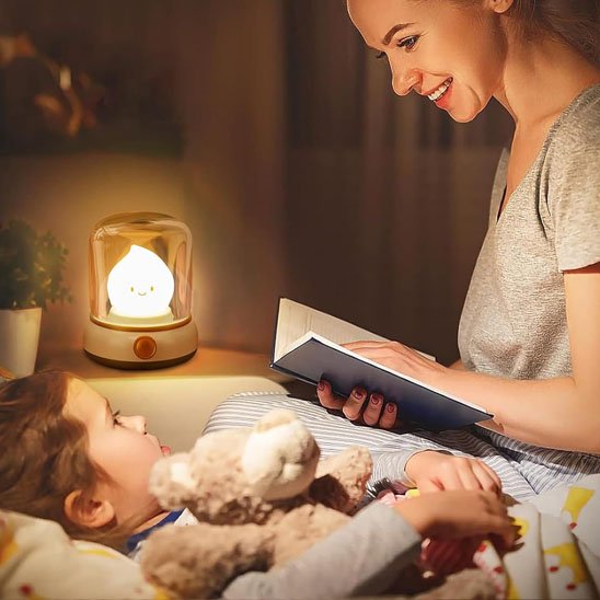 maman qui lit une histoire a son enfant calement blottit dans son lit avec sa veilleuse bebe