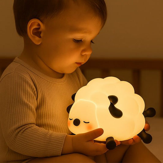 Bébé qui regarde tendrement sa veilleuse mouton avant de s endormir