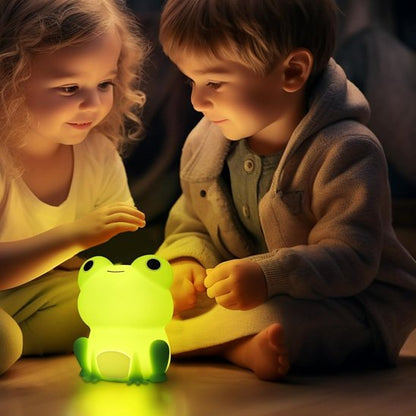 Petite fille et petit garcon qui jouent avec leur veilleuse personnage grenouille