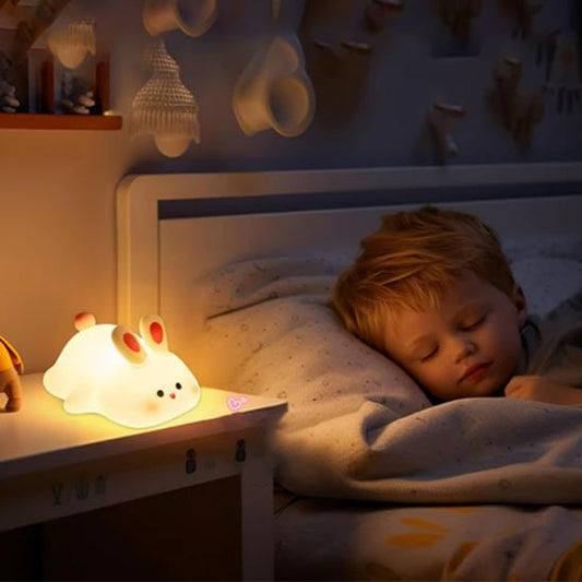 Veilleuse bébé Lapin Rêveur posée sur une table de chevet, lumière douce apaisante
