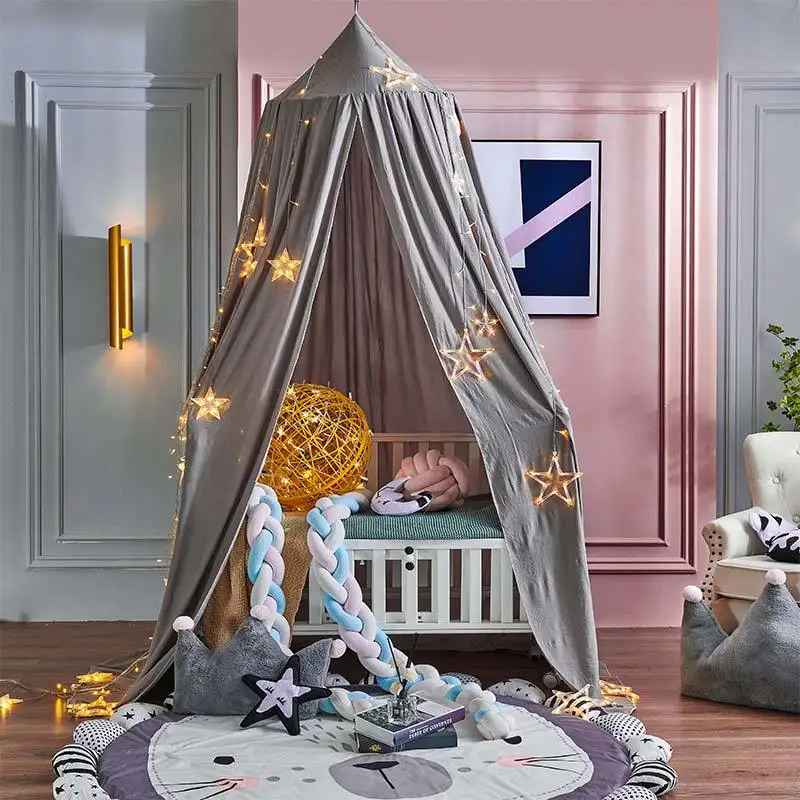 Ciel de lit beige décoré créant une ambiance chaleureuse dans une chambre d’enfant